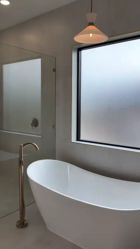 Soaking tub, glass shower and brushed-gold fixtures